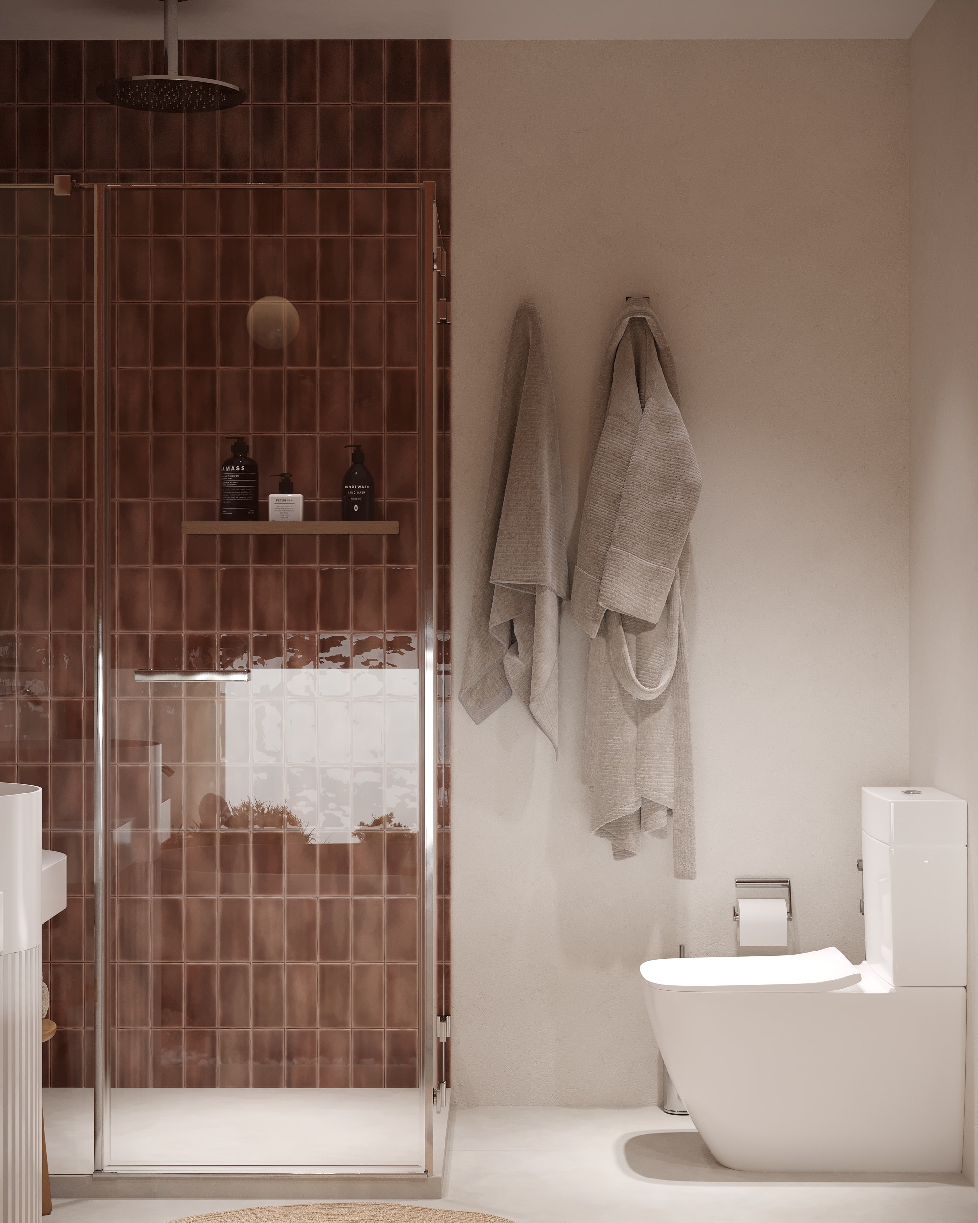 IO Villas — Bathroom 1: shower enclosure with terracotta tiles, wall-hung toilet and robe hooks